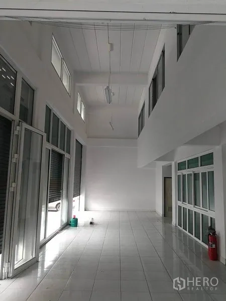 Warehouse for rent in Bang Phli, Samut Prakan - High-ceiling lobby space with tall windows and sliding doors in the industrial building.