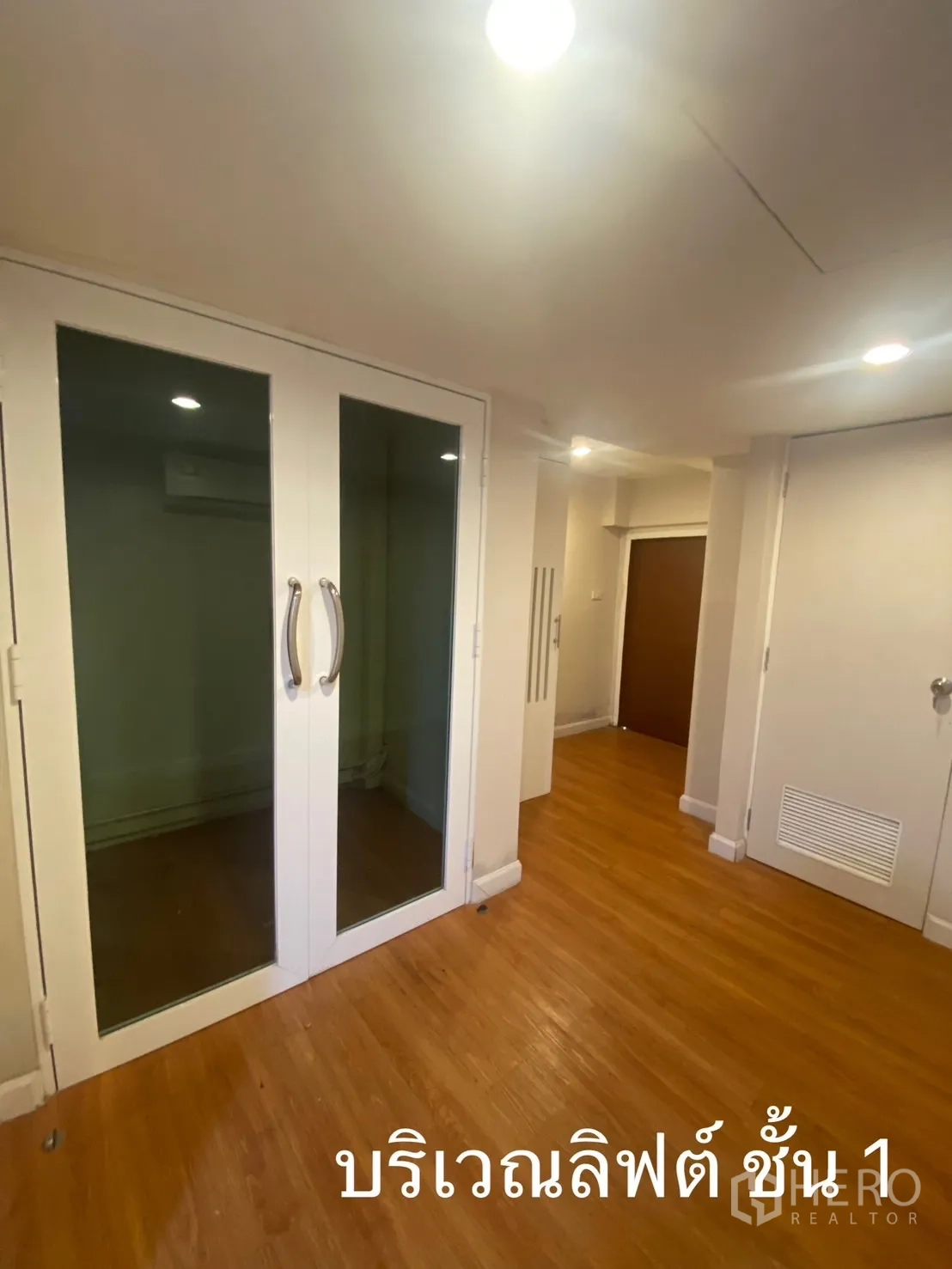 店屋 出租在Watthana, Bangkok - 电梯前厅，双扇玻璃门与木地板。