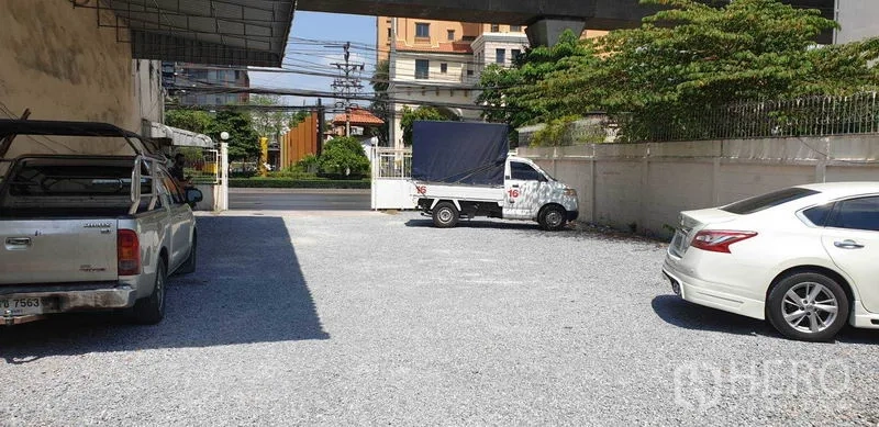 อาคารพาณิชย์ ให้เช่าในPhra Khanong, Bangkok - ลานจอดรถโรยหินกว้าง พร้อมรถกระบะและรถยนต์ ภายในรั้วติดถนนหลัก