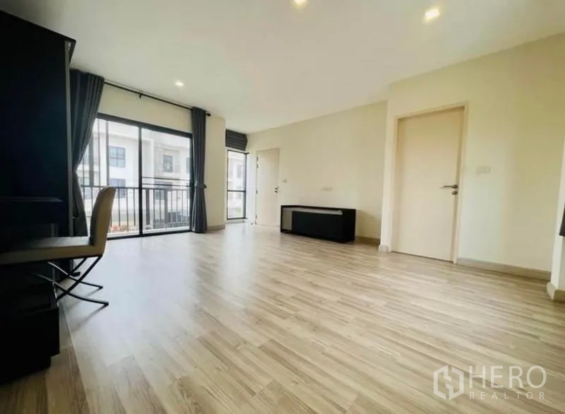 Townhouse for rent in Saphan Sung, Bangkok - Large multipurpose upstairs room with two balconies, wide windows and light wood floors.