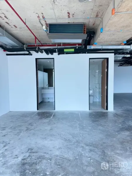 办公空间 出租在Din Daeng, Bangkok - 套内卫生间位于白色隔墙后，顶部为裸露机电管线的壳体办公区。