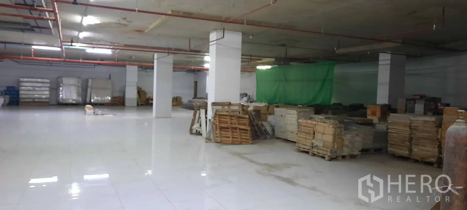 พื้นที่ขายของ for rent in Watthana, Bangkok - พื้นที่เก็บของโล่งมีพาเลตและวัสดุก่อสร้างบนพื้นเงา