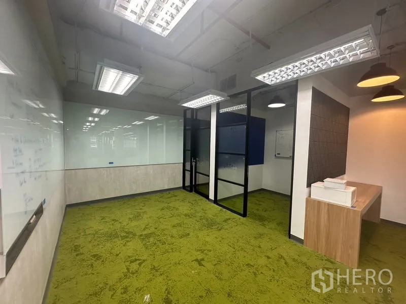 Office Space for rent in Bang Rak, Bangkok - Meeting room with green carpet, full-length whiteboards, and modern lighting.