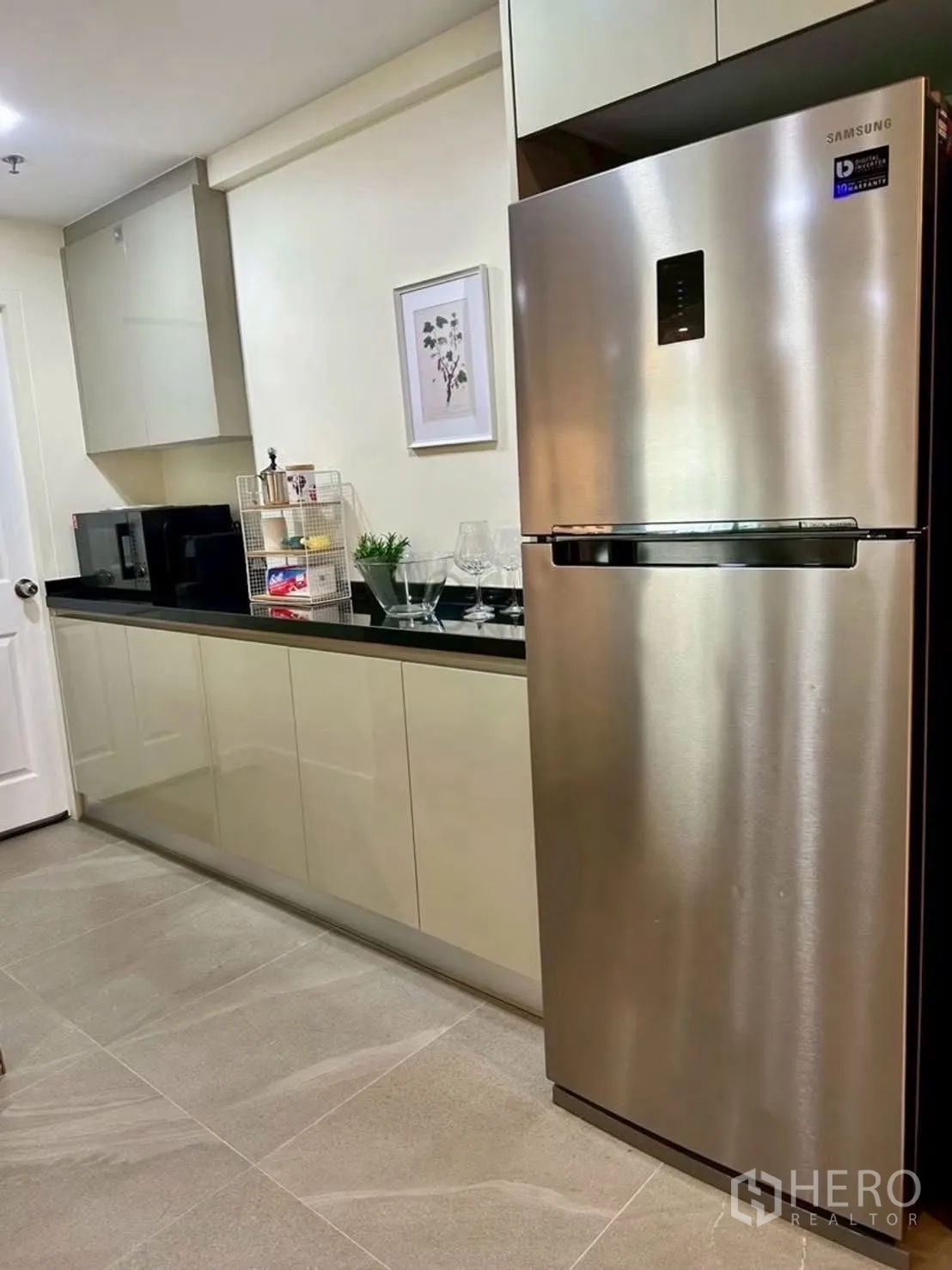 Condominium for rent in Huai Khwang, Bangkok - Separate kitchen with long counter and stainless refrigerator.