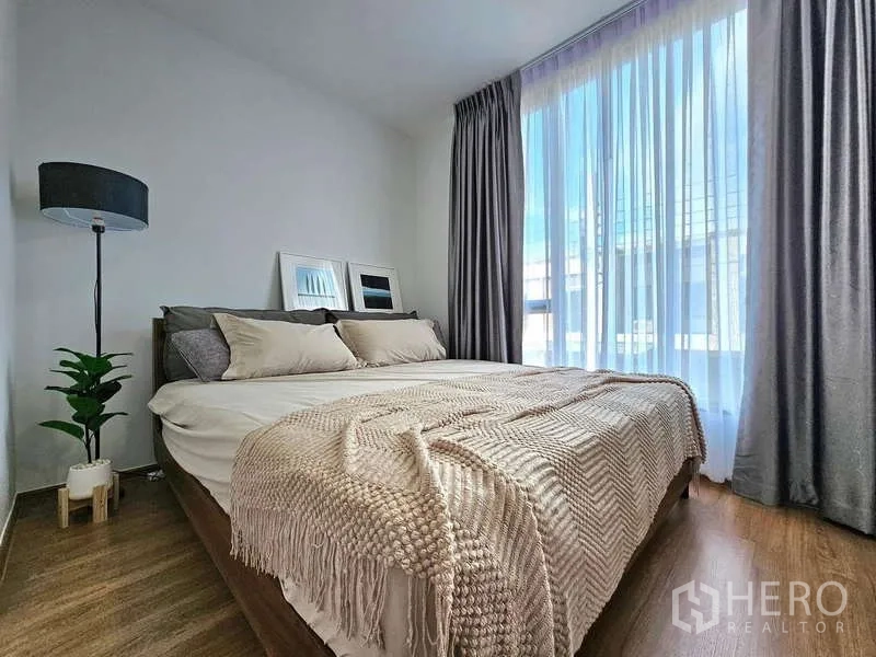 Townhouse for rent in Bang Phli, Samut Prakan - Master bedroom with king bed, floor‑to‑ceiling window and sheer curtains.
