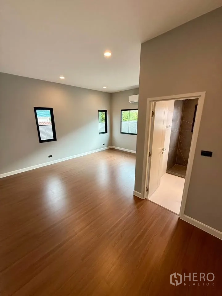 Detached House for rent in Don Mueang, Bangkok - Bedroom with en-suite bathroom and multiple windows.