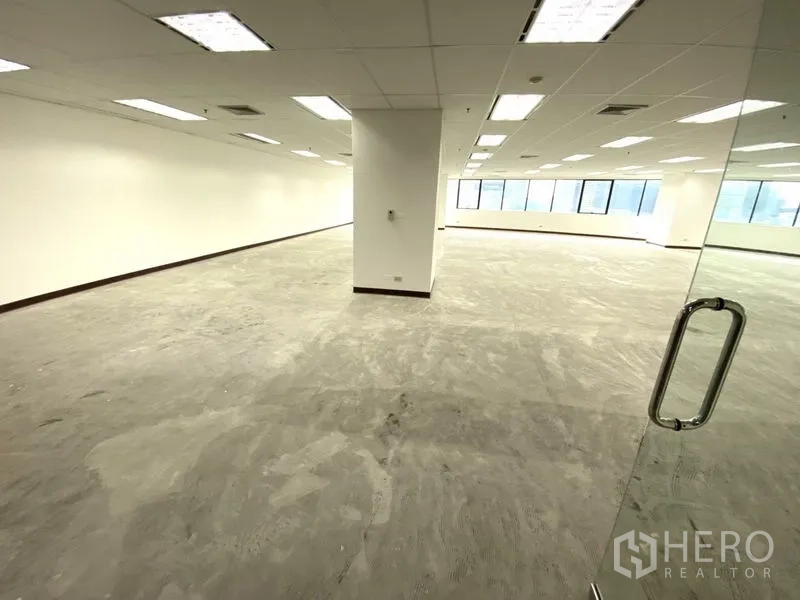 สำนักงาน ให้เช่า - สำนักงานโอเพนสเปซ 145 ตร.ม. ประตูกระจก ผนังสีขาว ฝ้าเพดานไลท์บ็อกซ์ และหน้าต่างบานยาว.