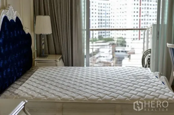 คอนโด ให้เช่าในKhlong Toei, Bangkok - ห้องนอนพร้อมหัวเตียงกำมะหยี่สีน้ำเงิน ประตูกระจกเปิดสู่ระเบียงวิวเมือง