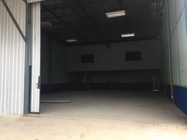 คลังสินค้า ให้เช่าในLat Krabang, Bangkok - ทางเข้าโกดังกว้าง ประตูเหล็กเปิดบางส่วน พร้อมพื้นที่โหลดสินค้า