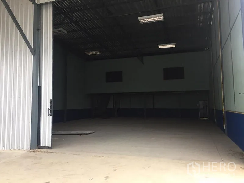 คลังสินค้า ให้เช่าในLat Krabang, Bangkok - ทางเข้าโกดังกว้าง ประตูเหล็กเปิดบางส่วน พร้อมพื้นที่โหลดสินค้า