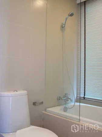 公寓 出租在Watthana, Bangkok - 整洁卫浴，浴缸、手持花洒与玻璃隔断。