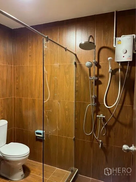 联排别墅 出租在Bang Na, Bangkok - 联排别墅外立面红色人字屋顶、黄色装饰及带门庭的车道。