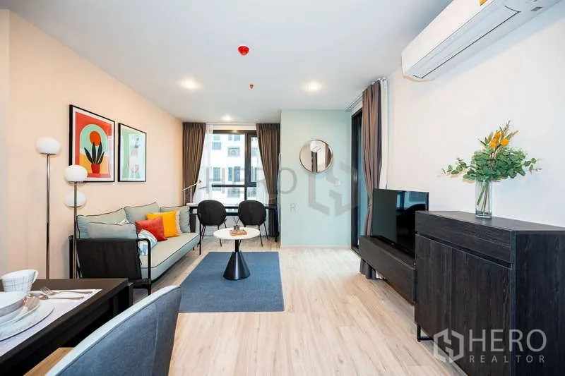 Condominium for rent or sale - Spacious living room facing balcony and flat-screen TV.
