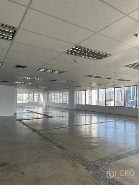 办公空间 出租在Pathum Wan, Bangkok - 开放式办公室，转角大窗、吊顶与城市景观。