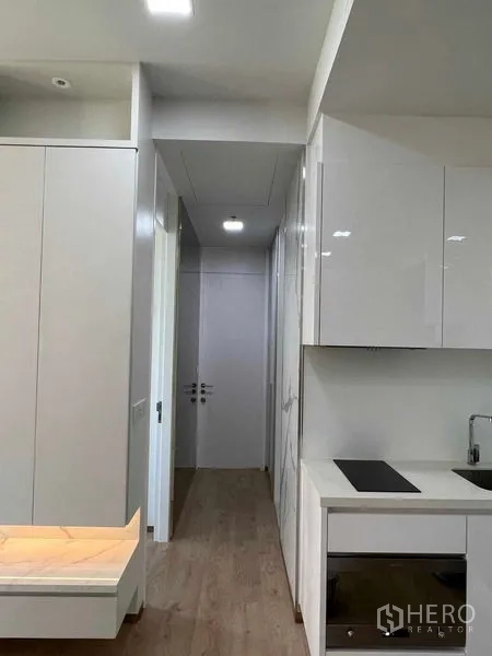 คอนโด ให้เช่าในWatthana, Bangkok - โถงทางเดินจากครัว พร้อมตู้ผิวเงาและพื้นไม้