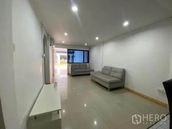 ทาวน์เฮาส์ ให้เช่าในKhlong Toei, Bangkok - ห้องนั่งเล่นแบบเปิดโล่ง มีโซฟาสีเทา หน้าต่าง และพื้นกระเบื้องเงา ใต้แสงดาวน์ไลท์