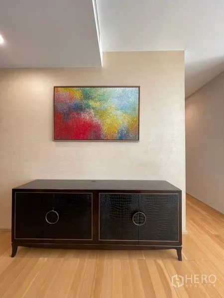 คอนโด ให้เช่าในWatthana, Bangkok - โถงทางเดินมีตู้คอนโซลสีดำและภาพศิลปะสีสันสด