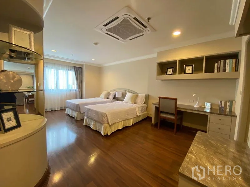 Condominium for rent in Watthana, Bangkok - Second bedroom with twin beds, study desk, shelving and wood floors.