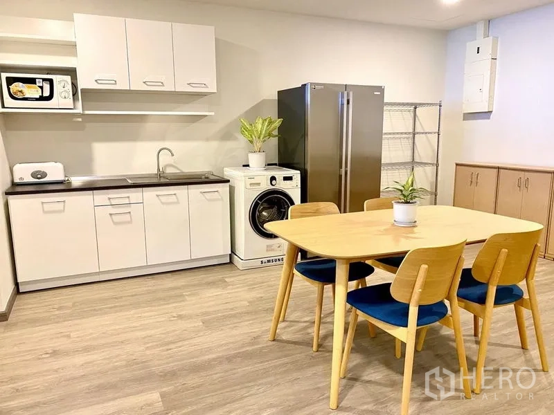 คอนโด ให้เช่า - ครัวเปิดตู้สีขาว ชุดโต๊ะอาหาร เครื่องซักผ้า และตู้เย็นสองประตู