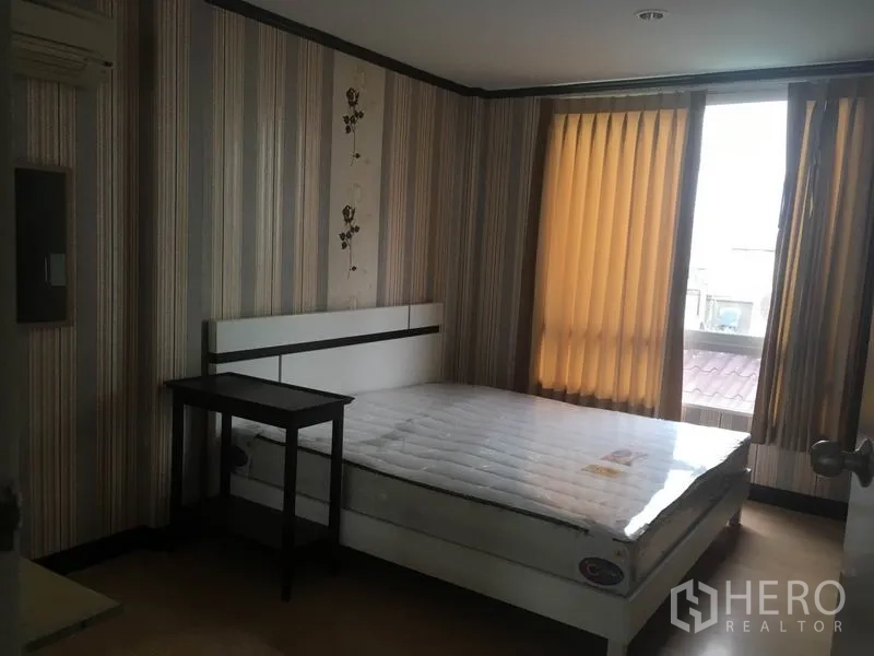 Townhouse for rent in Din Daeng, Bangkok - Third bedroom with striped wallpaper, bed and natural light.