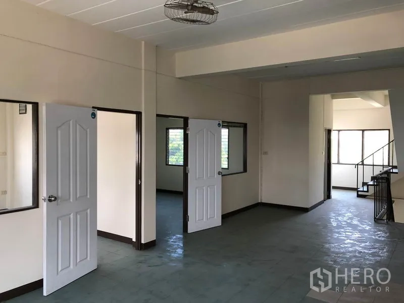 Shophouse for sale in Lam Luk Ka, Pathum Thani - Partitioned rooms with white doors and windows on the upper level.