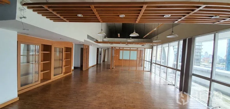 Office Space for rent in Watthana, Bangkok - Spacious open-plan area with slatted ceiling features, wall shelving, and floor-to-ceiling windows.