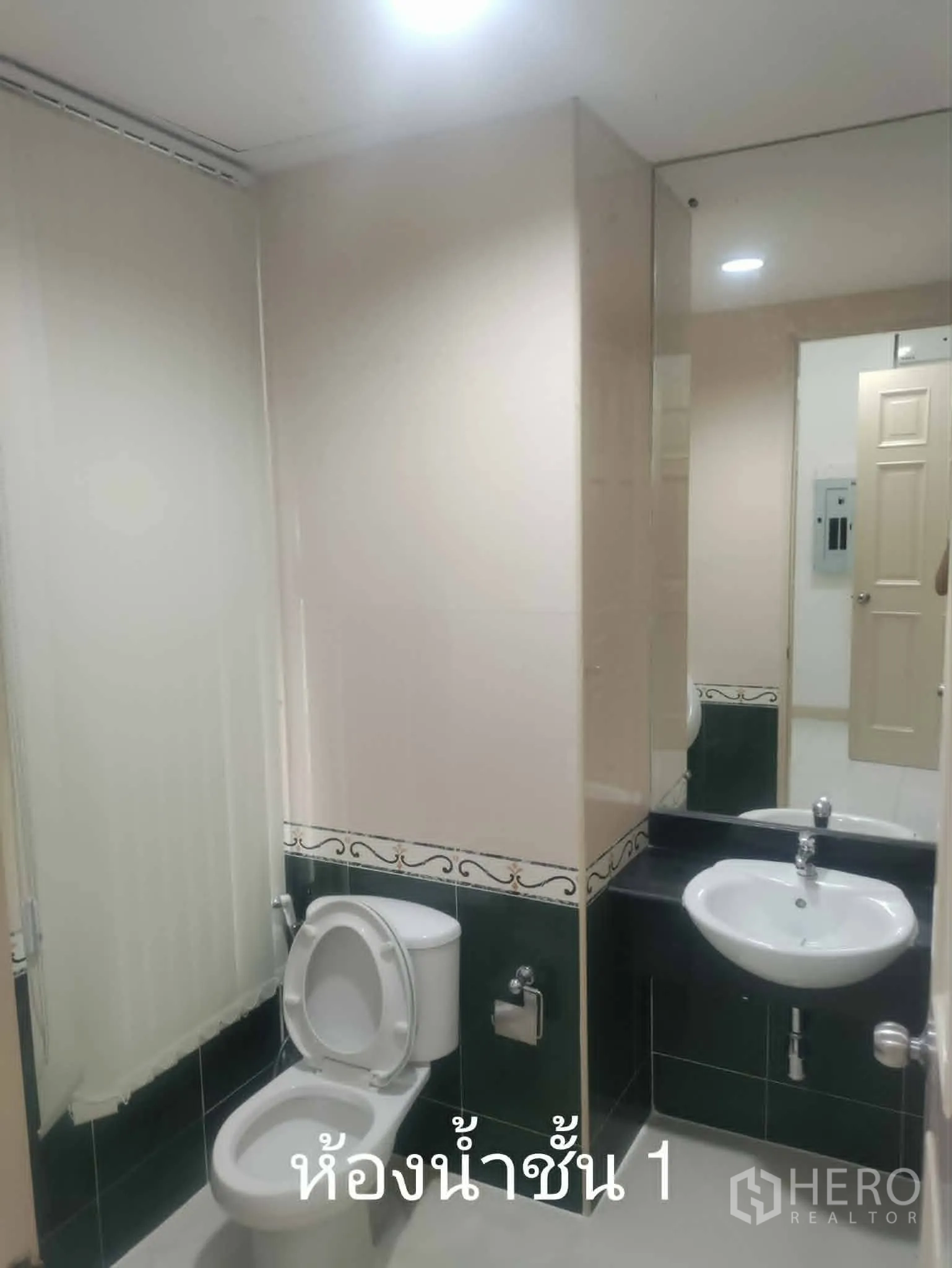 Home Office for rent in Lat Phrao, Bangkok - Ground-floor bathroom with toilet, sink, and full-height mirror.