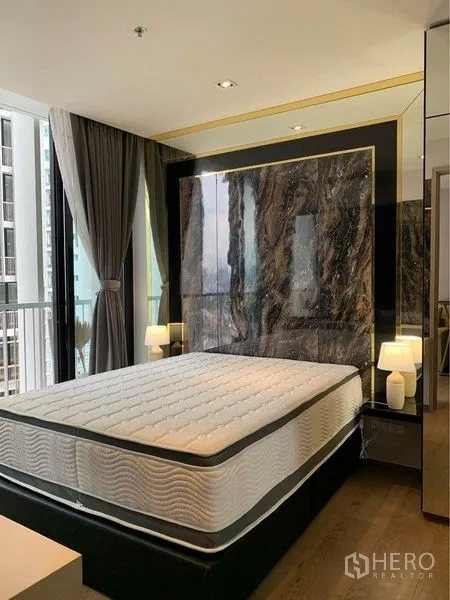 คอนโด ขาย - ห้องนอนสไตล์โมเดิร์น ผนังหัวเตียงลายหินอ่อน โคมไฟข้างเตียง และกระจกระเบียง เขตคลองเตย