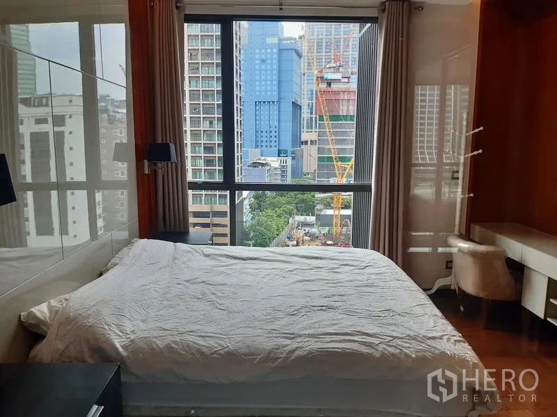 公寓 出租在Khlong Toei, Bangkok - 采光良好的卧室，落地窗与书桌角，俯瞰空堤区高楼景致。