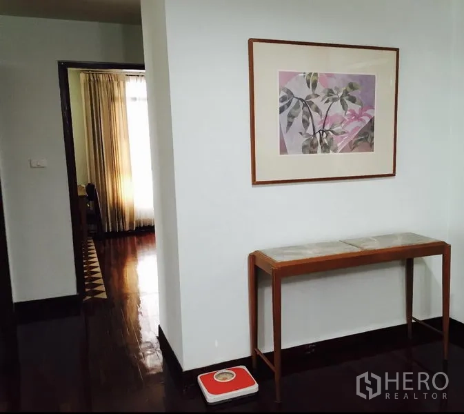 คอนโด ให้เช่าในWatthana, Bangkok - โถงทางเดินสว่าง ติดภาพศิลปะและโต๊ะคอนโซล พื้นไม้เข้ม เชื่อมไปยังห้องที่มีผ้าม่าน