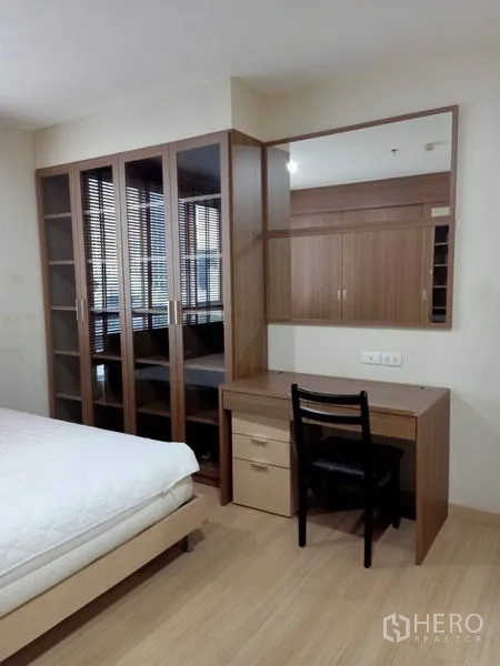 Condominium for rent in Bang Rak, Bangkok - Bedroom dressing area with glass-front cabinets, built-in vanity and mirror.