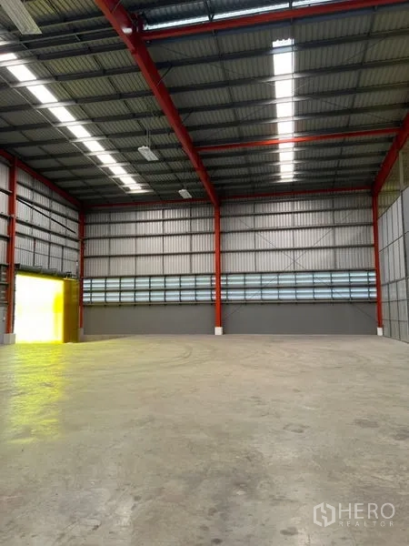 Warehouse for rent in Pathum Thani - Spacious warehouse interior with skylight strips and clear-span storage area.