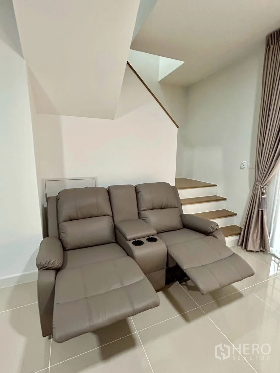 Townhouse for rent in Bang Phli, Samut Prakan - Recliner sofa with footrests extended beside stairs.