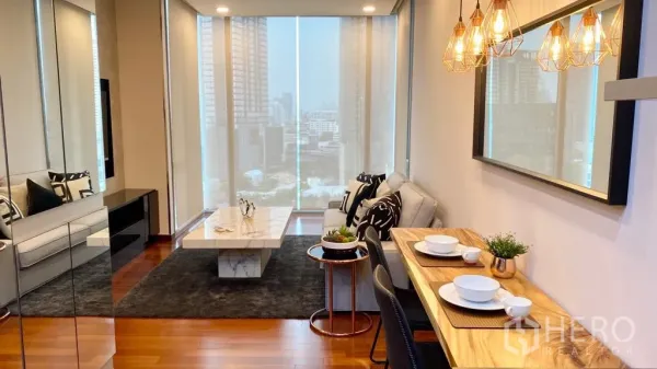 公寓 出售在Khlong Toei, Bangkok - 明亮的客餐厅，吊灯、石材茶几，落地窗外城市天际线景观。