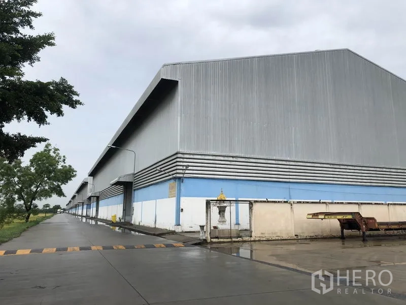 货栈 出租在Phra Nakhon Si Ayutthaya - 大城府邦帕茵区的金属外墙仓库外观，配有长车道与装卸区。