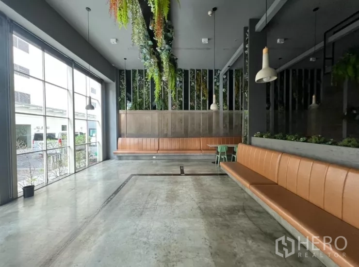 零售空间 出租 - 采光充足的就座区，整面落地窗与棕色长条卡座。