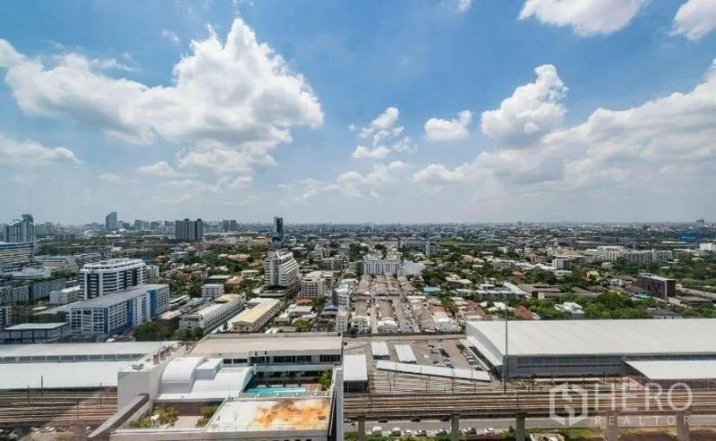 Condominium for rent - Panoramic Bangkok skyline view from a high-floor condo with rail tracks and pool below.