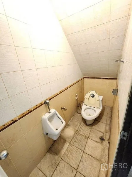 店屋 出租在Bang Rak, Bangkok - 带斜顶的小型瓷砖卫生间，配坐厕和小便池