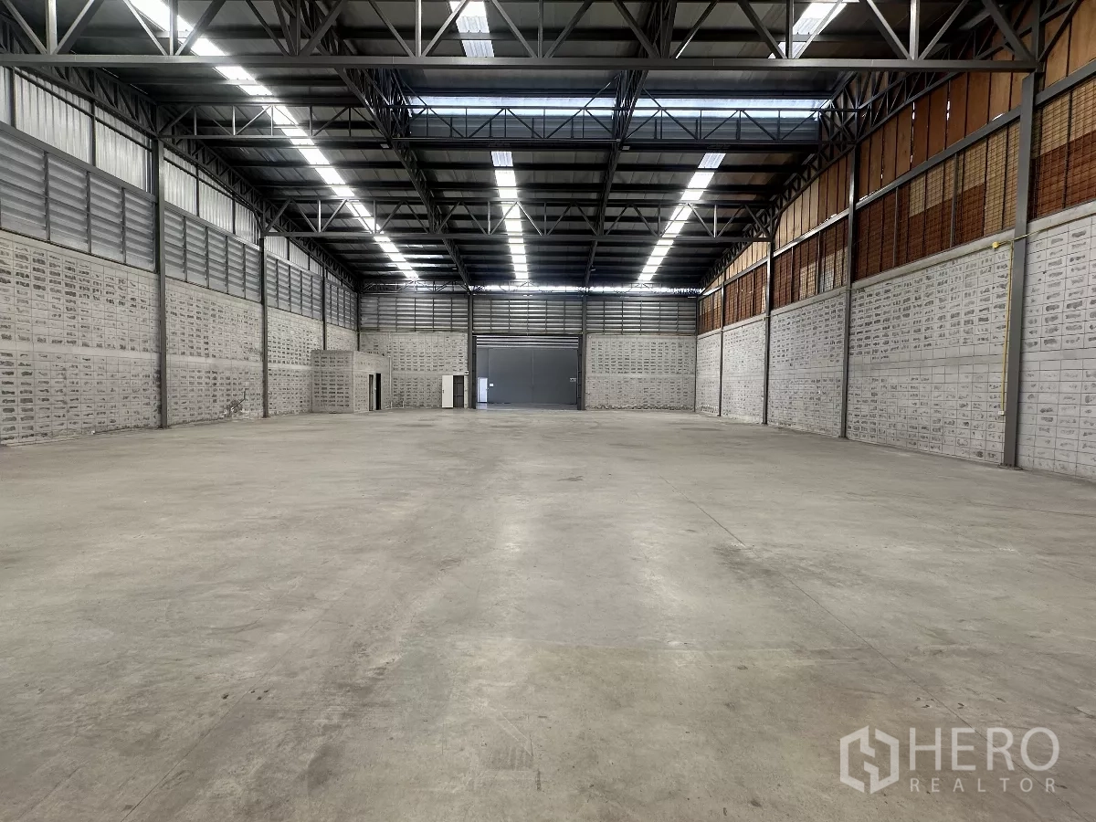 Warehouse for rent in Khlong Toei, Bangkok - Spacious warehouse interior with high steel-truss roof, skylights and smooth concrete floor.