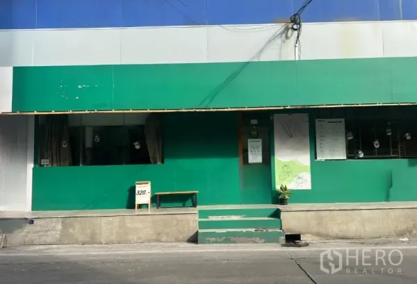 พื้นที่ขายปลีก ให้เช่าในKhlong Toei, Bangkok - หน้ากว้างผนังสีเขียว มีบันไดขึ้นจากทางเท้าและช่องหน้าต่าง.