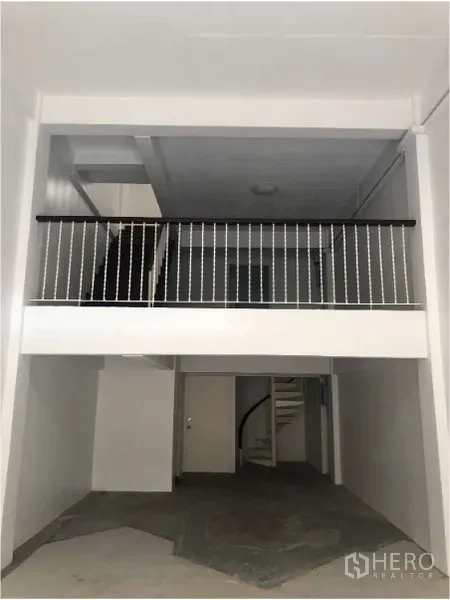 店屋 出租在Watthana, Bangkok - 底层挑高带夹层与栏杆的商铺空间，待装修使用。