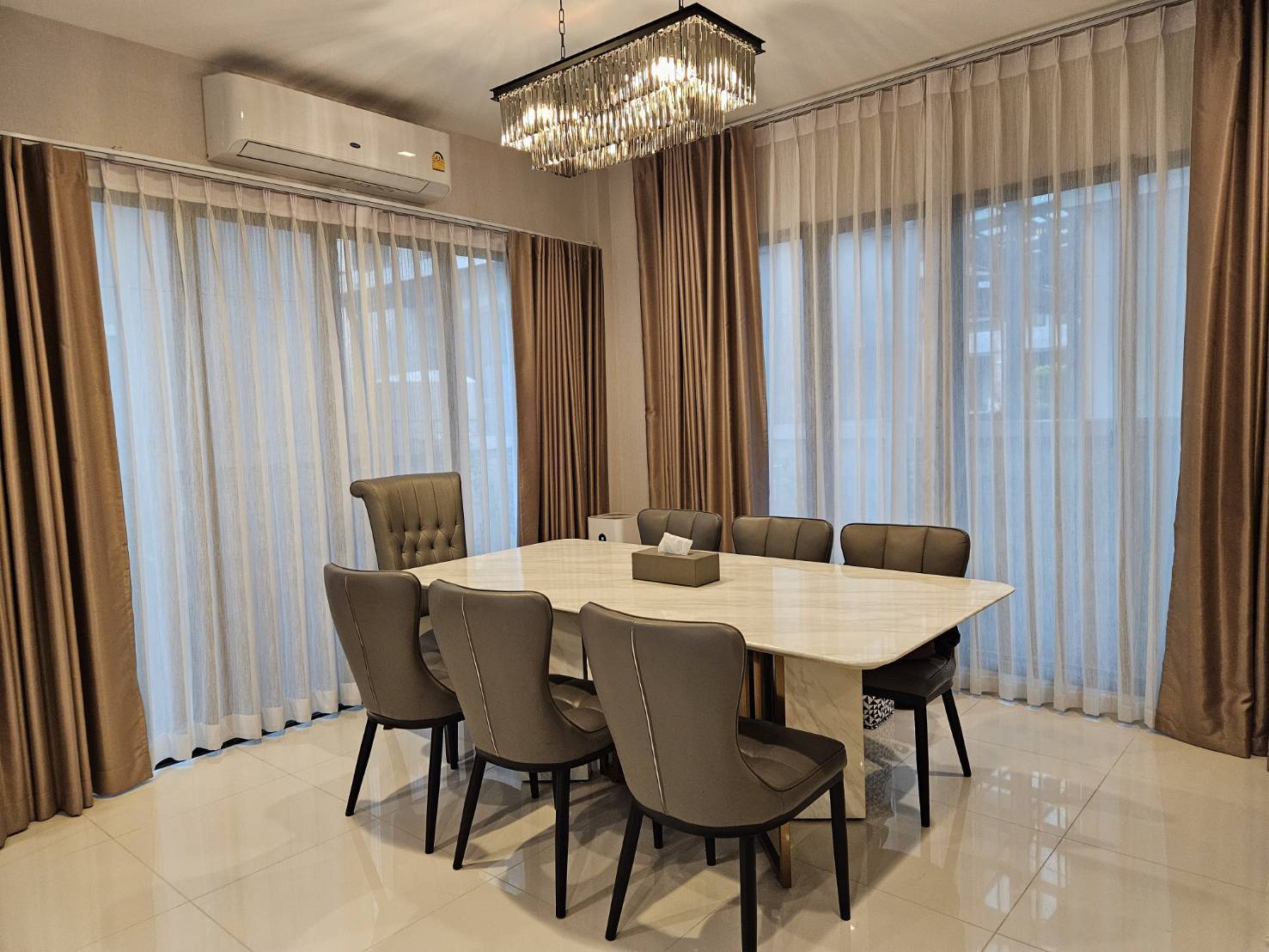 Detached House for rent in Saphan Sung, Bangkok - Dining room with eight-seat marble table, crystal chandelier and sheer drapes.