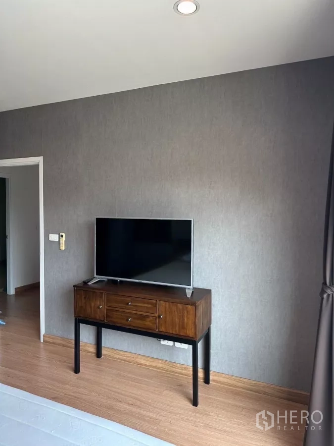 บ้าน ให้เช่าในSuan Luang, Bangkok - ผนังตรงข้ามเตียงพร้อมทีวีวางบนคอนโซลไม้ พื้นลามิเนต.