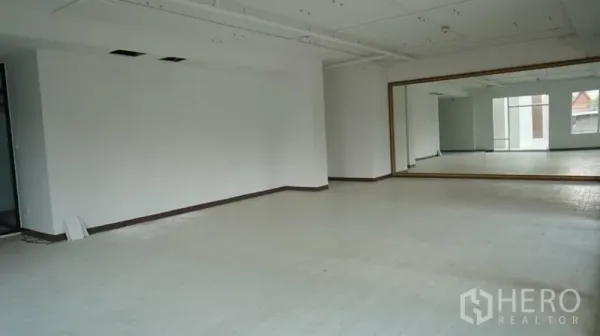 零售空间 出租在Khlong Toei, Bangkok - 开放式零售空间，配有超大镜面、白色地面与外露天花，布局灵活。