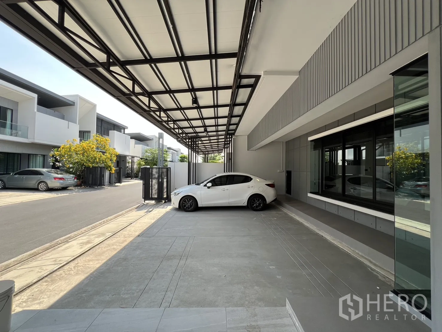 Detached House for rent in Bang Phli, Samut Prakan - Covered parking area with metal roof looking out to a quiet residential street.
