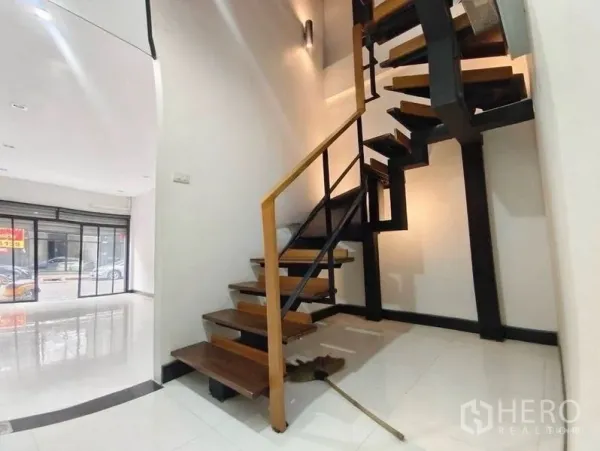Shophouse for rent or sale in Pom Prap Sattru Phai, Bangkok - Industrial-style staircase with metal frame and wooden treads leading to upper floors.