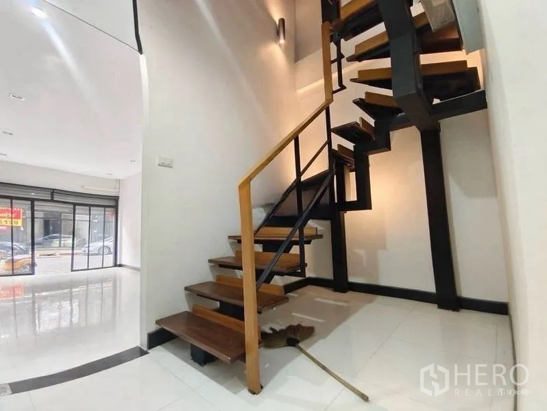 Shophouse for rent or sale in Pom Prap Sattru Phai, Bangkok - Industrial-style staircase with metal frame and wooden treads leading to upper floors.