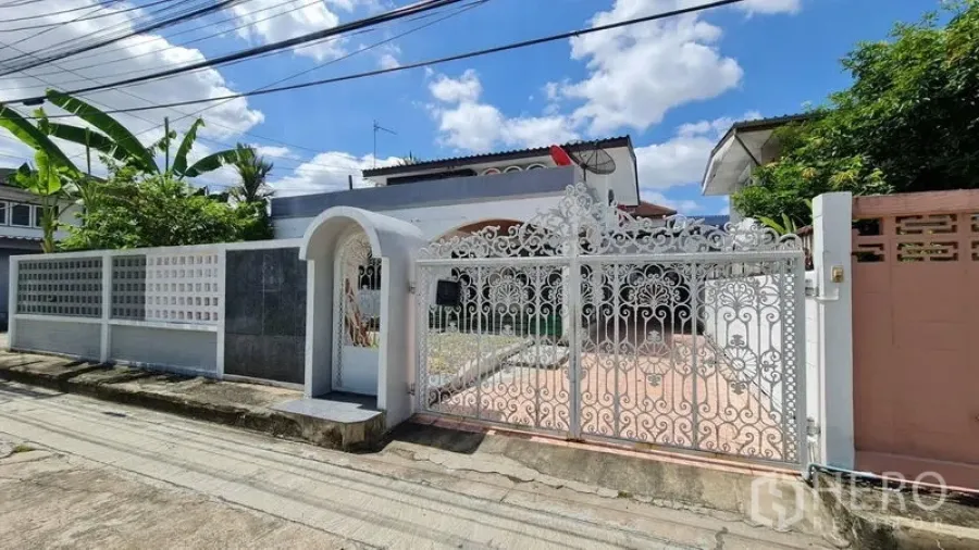 独立式住宅 出租在Lat Phrao, Bangkok - 物业临街面的白色花纹铁艺大门与围墙。