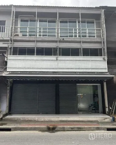 อาคารพาณิชย์ ให้เช่าในHuai Khwang, Bangkok - ด้านหน้าตึกแถว 3 ชั้น ประตูกระจก ประตูเหล็กม้วน และราวระเบียงโลหะ