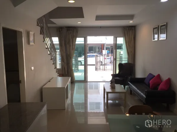 Townhouse for rent in Bang Kho Laem, Bangkok - Bright ground-floor living area with glossy tiles, recessed lighting and sliding doors opening to the front patio.